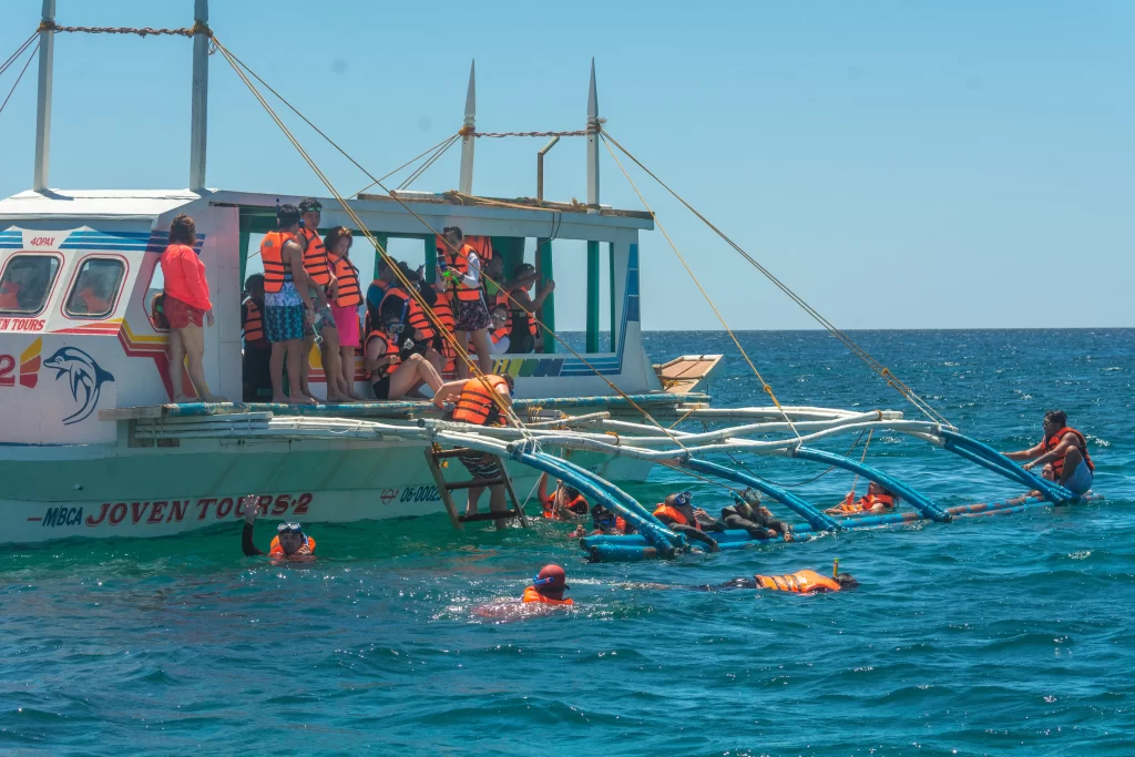 tourists enjoying swimming while on island hopping
