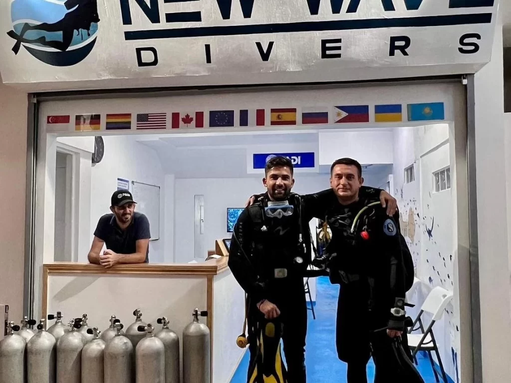 a diver with its dive instructor posed for a photo at New Wave Divers Center