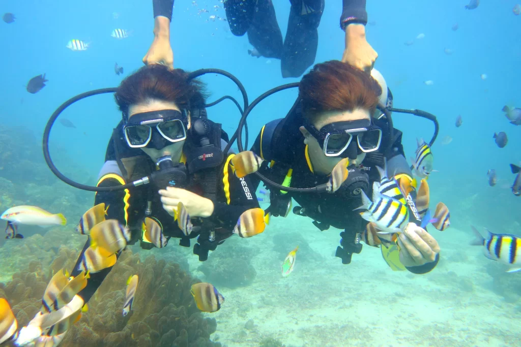 a couple went for Boracay scuba diving with their dive instructor holding them