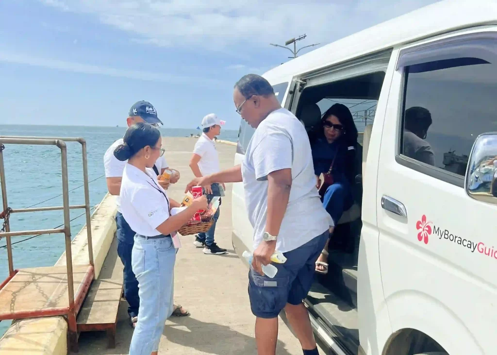 trainees giving cold towels to guests at the Boracay port