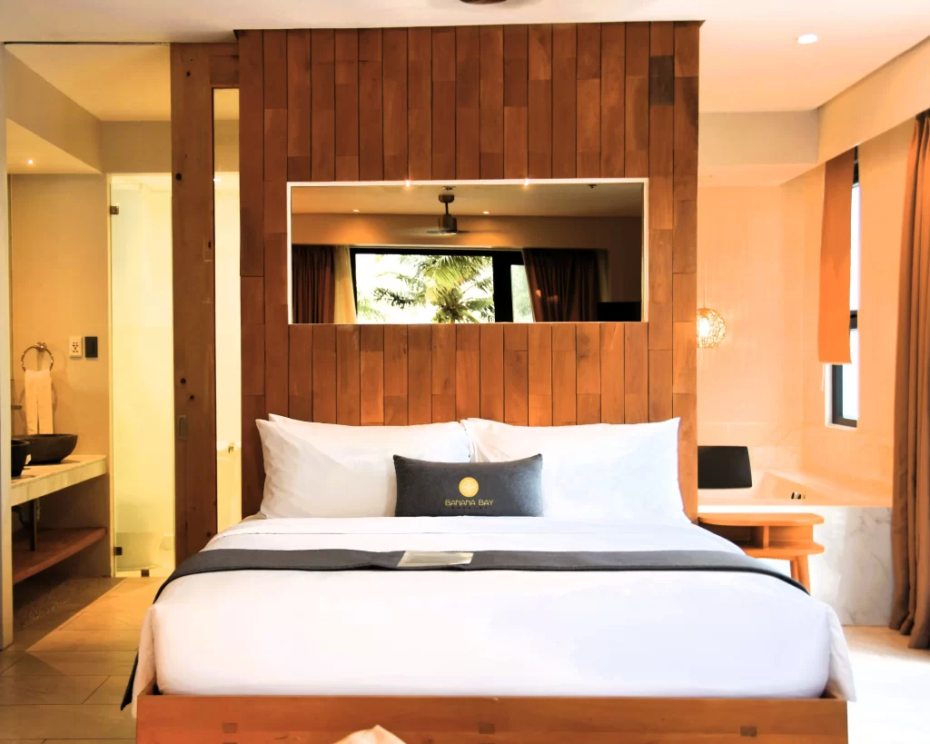 Modern hotel room interior at Banana Bay Boracay with a king-size bed and warm wooden accents